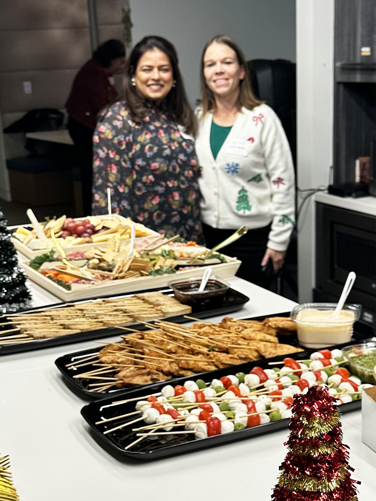 women at holiday party with food on buffet
